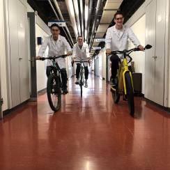 研究所内を自転車で移動する堂前氏と同僚の研究者たち