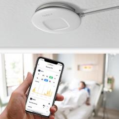 病室の天井に設置されたセンサーで、部屋の大きさに関係なく室内4名まで利用可能。各々の患者の状況をスマホ専用アプリでモニタリングする。©QUMEA