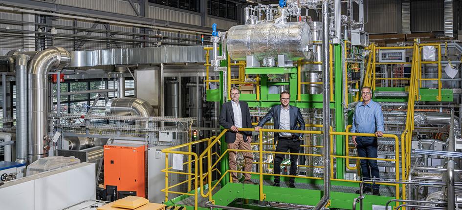 Andreas Aeschimann and Luca Schmidlin from AlphaSYNT and Tilman Schildhauer from PSI in front of the GanyMeth pilot plant at PSI. 