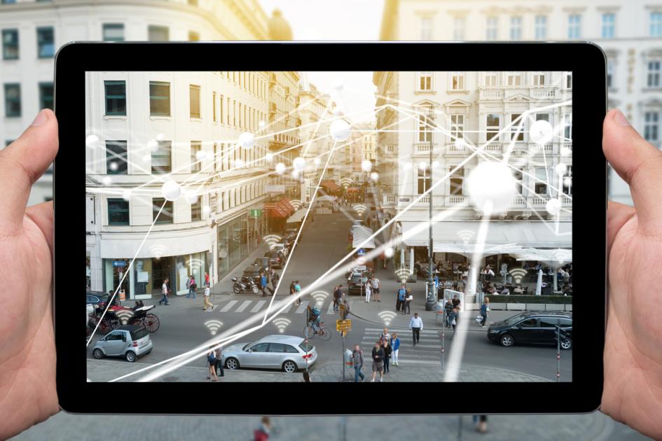Mano sosteniendo tableta y átomos blancos conectados con la vista de la ciudad. Descripción IPTC tecnología financiera, internet de las cosas y cadenas de bloque