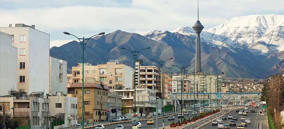Vue sur une rue de Téhéran avec la tour Azadi en arrière-plan