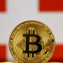 Versione fisica del Bitcoin e bandiera della Svizzera. 