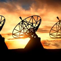 Three satelite dishes over sunset