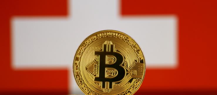 Versione fisica del Bitcoin e bandiera della Svizzera. 