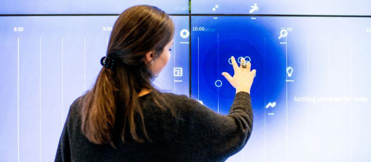 Woman at big touch screen.