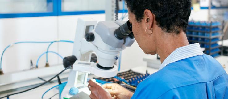 Donna che esamina campioni al microscopio