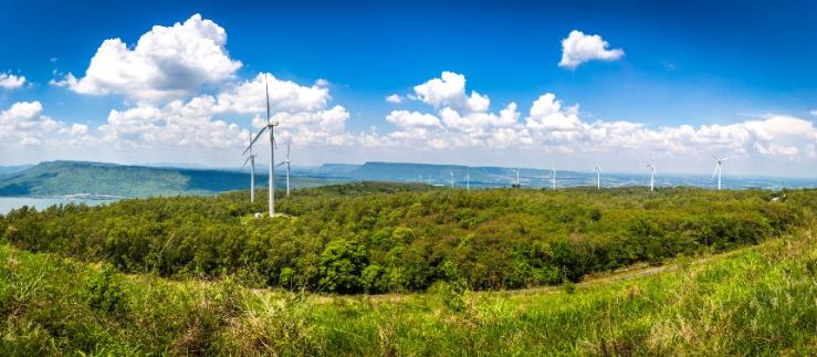 Landschaft mit vielen Windkraftanlagen auf dem weiten Grasland mit Bergen und Himmel als Hintergrund in Nakhon Ratchasima Thailand