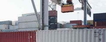 Container in fase di carico al porto.