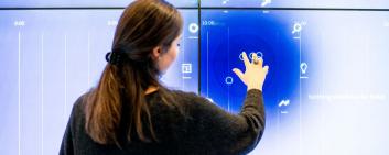 Woman at big touch screen.