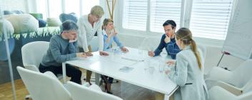 Cinq personnes discutent planification lors d’une réunion en équipe réduite