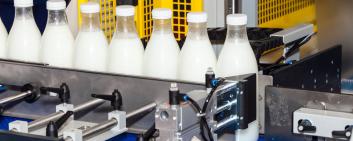 Bottiglie di latte sul nastro di produzione