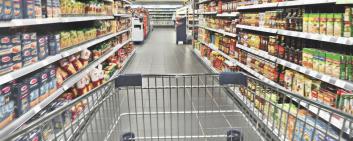 A shopping cart between two shelves.